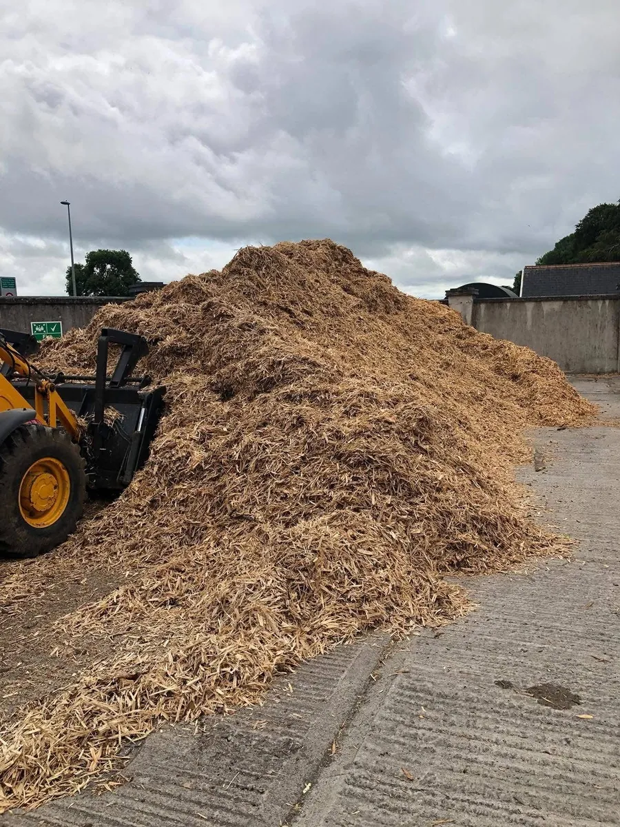 Loose pile of bulk animal bedding loaded by machine for delivery across Ireland